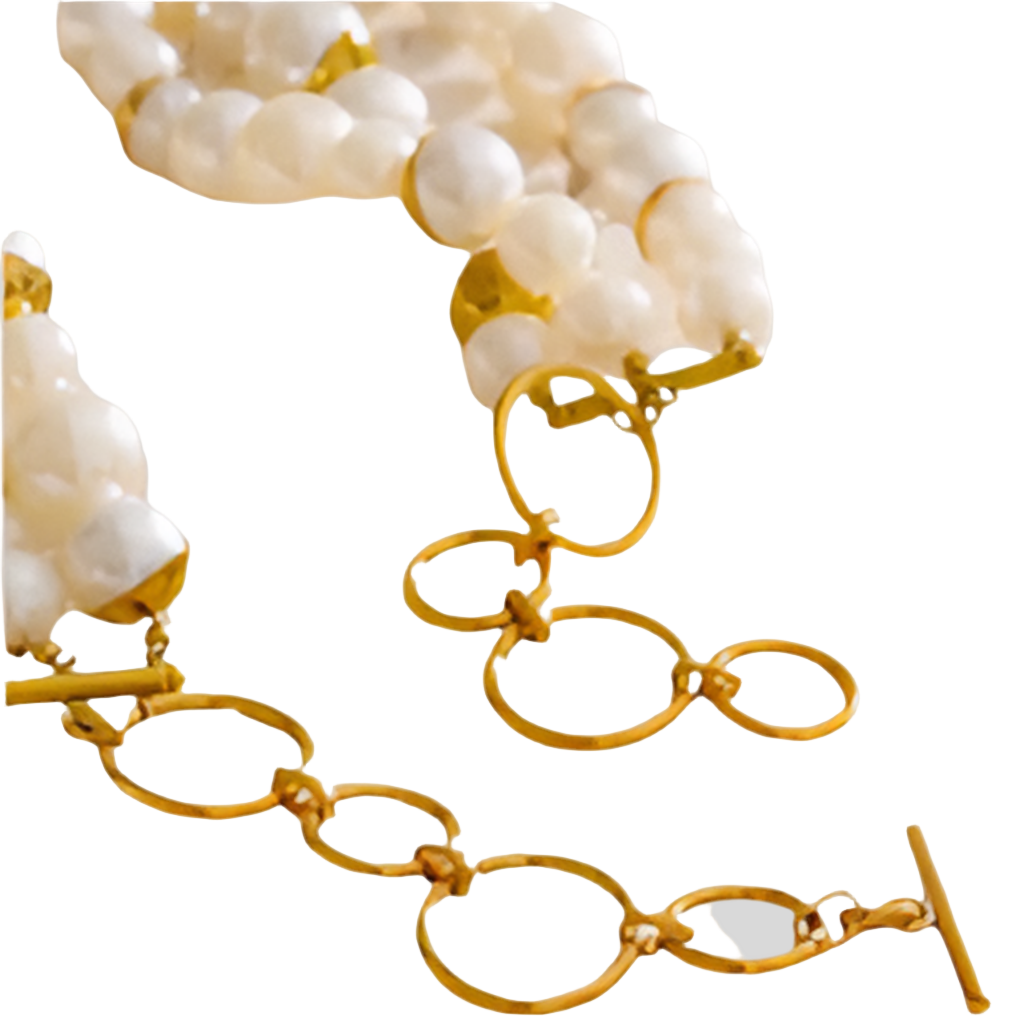 Gold chain necklace with white pearls on a light gray background