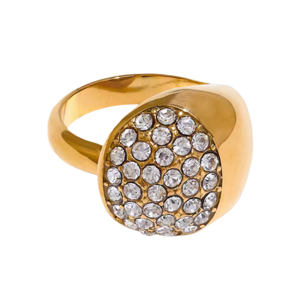 Gold ring with crystal stones on a light gray background