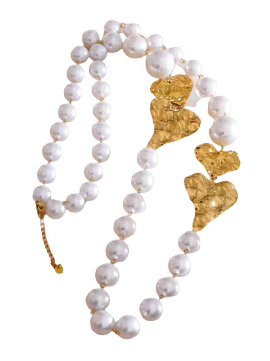 Pearl necklace with gold heart-shaped clasps on a light gray background