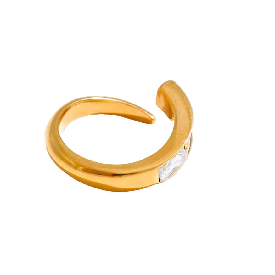 Gold open ring with a clear gemstone on a gray background