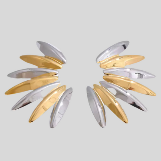 Pair of gold and silver earrings on a light gray background