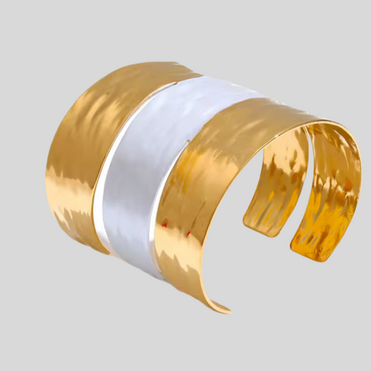Gold and white cuff bracelet on a light gray background