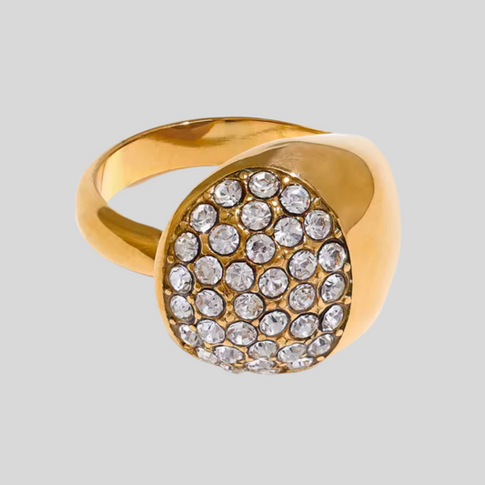 Gold ring with crystal stones on a light gray background