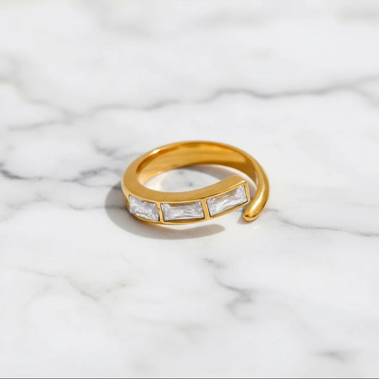 Gold ring with embedded diamonds on a marble surface