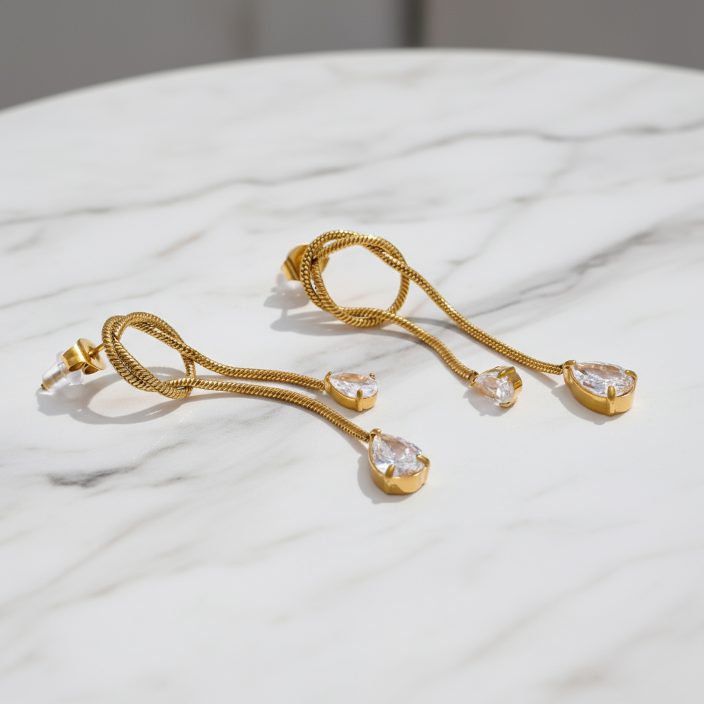 Gold necklace with heart-shaped pendants on a white fabric background