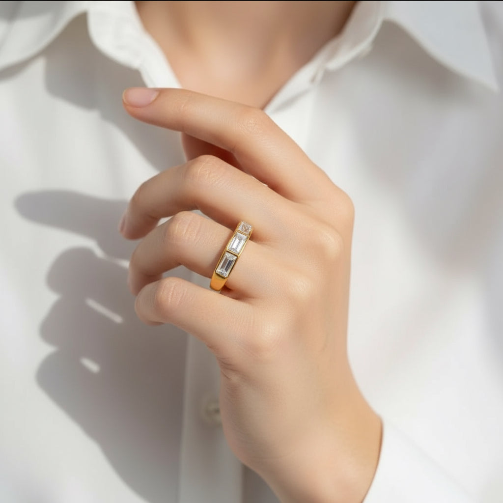 Hand wearing a gold ring with a diamond on a white background