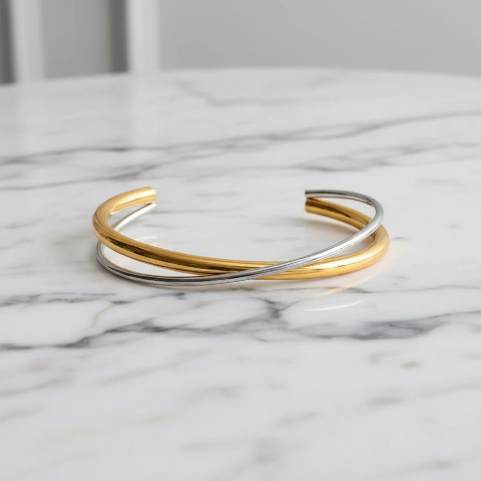 Three gold and silver bangles on a marble surface