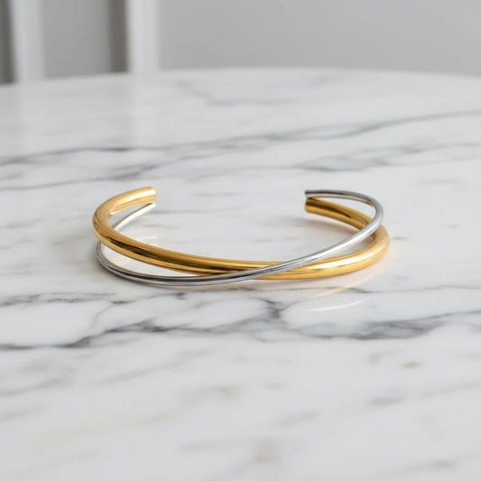 Three gold and silver bangles on a marble surface