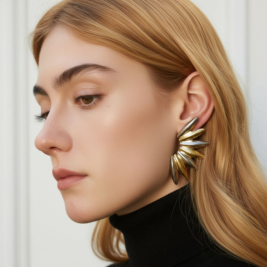 Woman wearing gold earrings with a blurred natural background