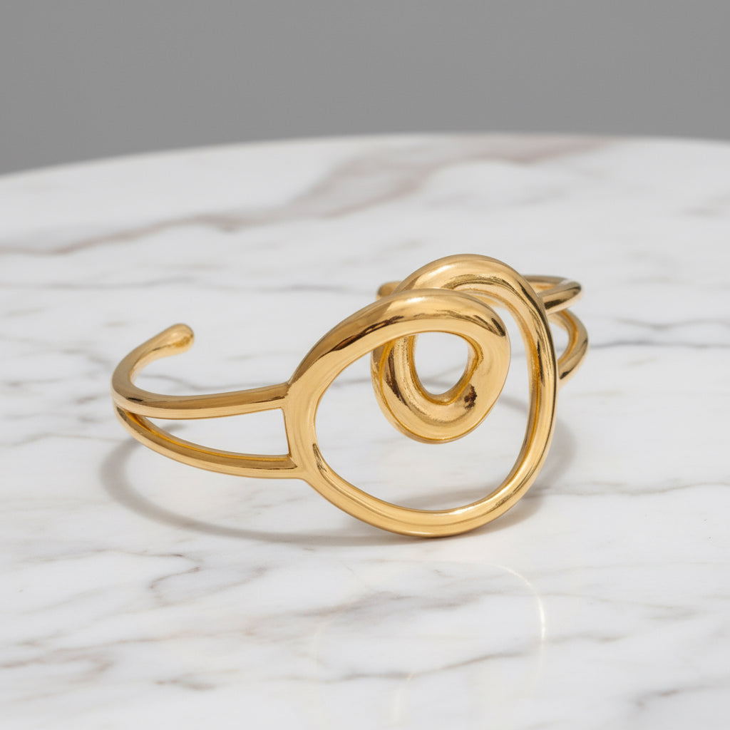 Gold spiral bracelet on a gray background