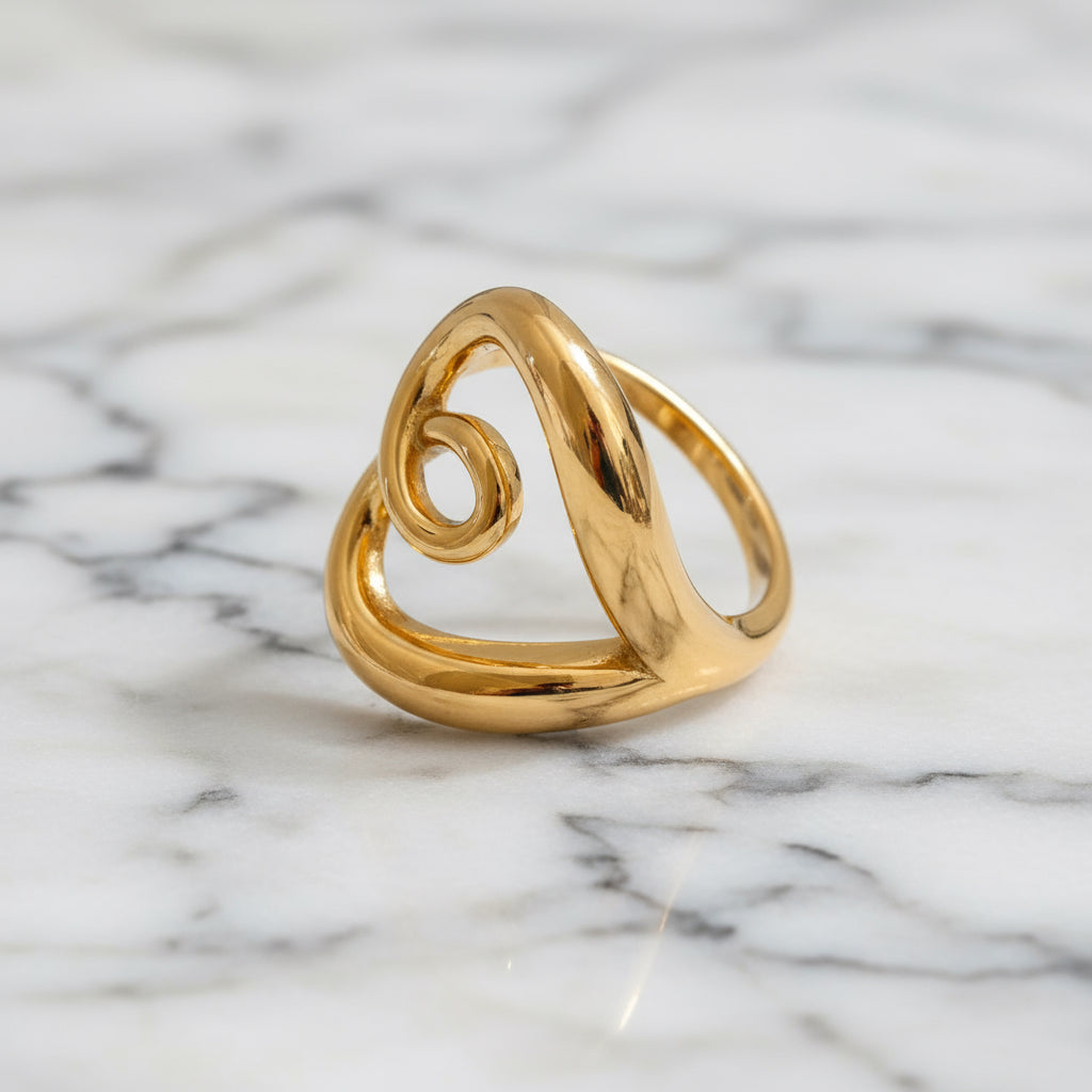 Gold ring with a spiral design on a gray background