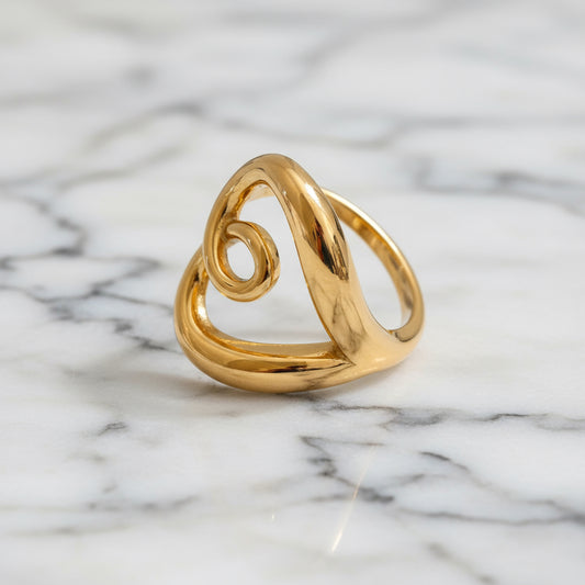 Gold ring with a spiral design on a gray background