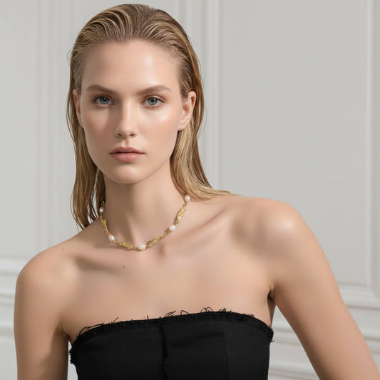 Woman wearing a strapless brown dress and pearl necklace against a gray background